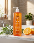 Boots Vitamin C Brightening Shower Serum - Flacon pompe orange sur marbre avec oranges et eucalyptus